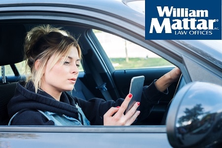 Girl driving car and texting on her smart phone