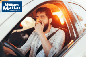 man yawning while driving car