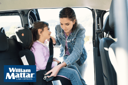mother helping her daughter with booster seat