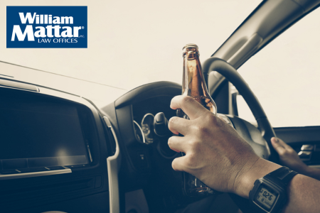 man drinking a beer while driving