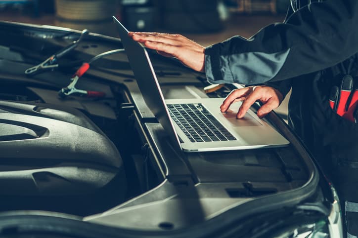 mechanic running diagnostics on car