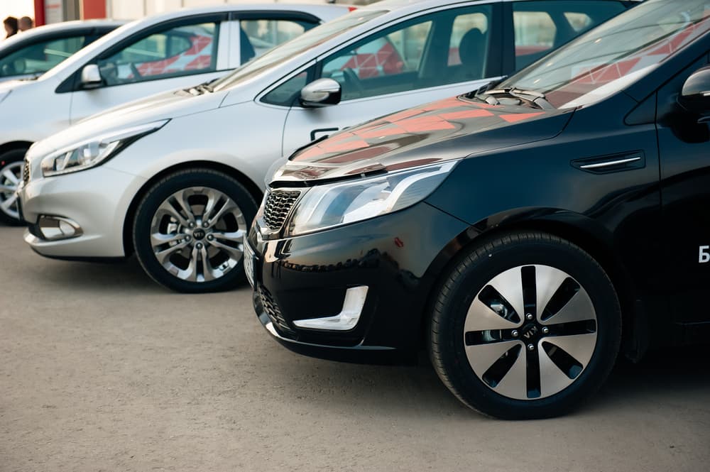 Closeup of several kia cars put together in front of the showroom