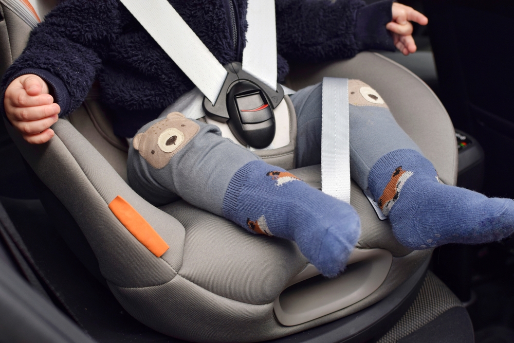 A young child in a specialized car seat with seat belts. Ensuring child safety while traveling.