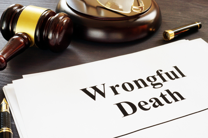 wrongful death written on a document with a law hammer next to it