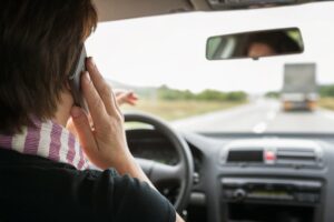 Woman using mobile phone while driving a car