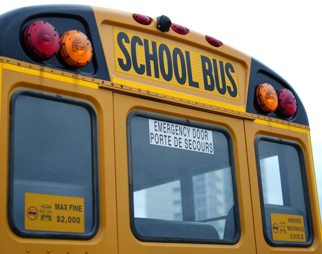Long Island bus accident lawyer reviewing rear view of school bus involved in roadway incident