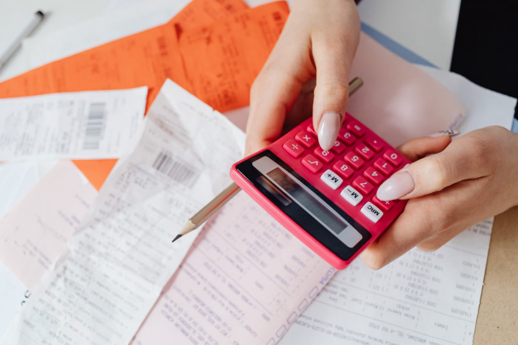 A person totaling medical bills and receipts with a calculator after a motorcycle crash in New York where no-fault coverage does not apply